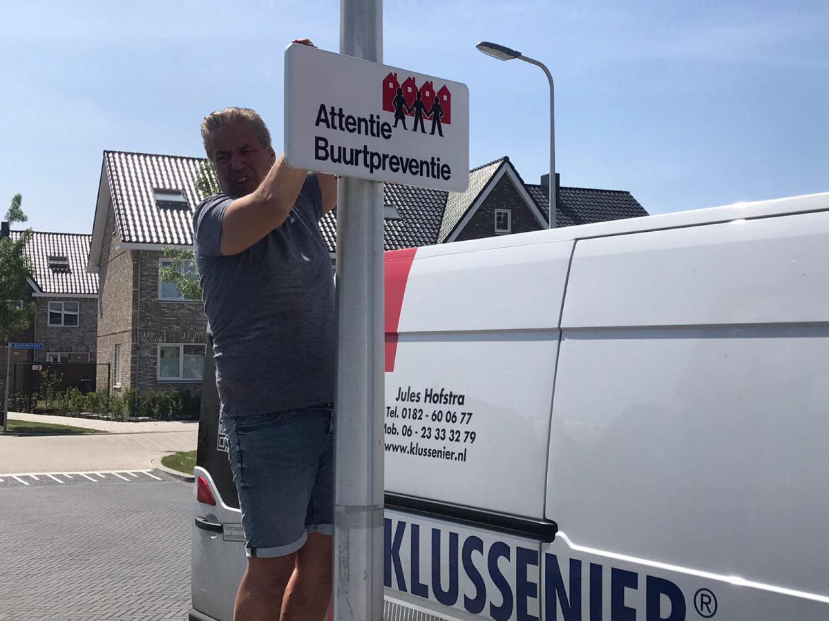 Klussenier Jules Hofstra plaatst borden voor buurtpreventie